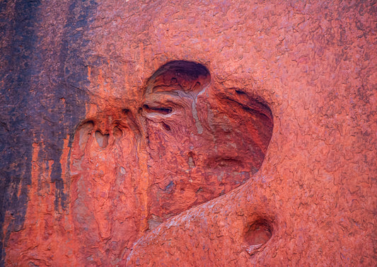 Heart of Uluṟu — fine art close-up photograph of Uluṟu rock surface with a natural heart-shaped formation in rich burnt orange, red and deep purple tones, archival Australian landscape print