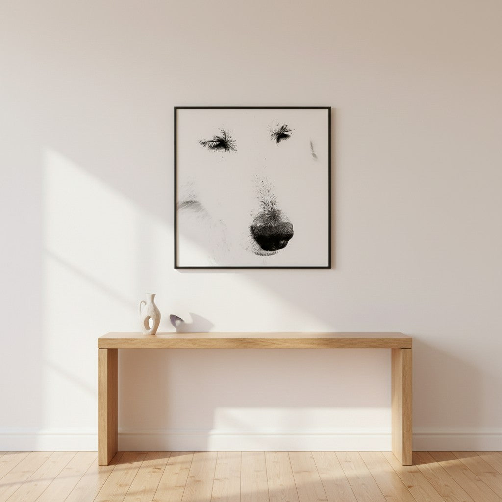 Mystery Maremma fine art portrait in a thin black frame above a timber console table in a bright minimalist hallway — unframed black and white dog portrait wall art