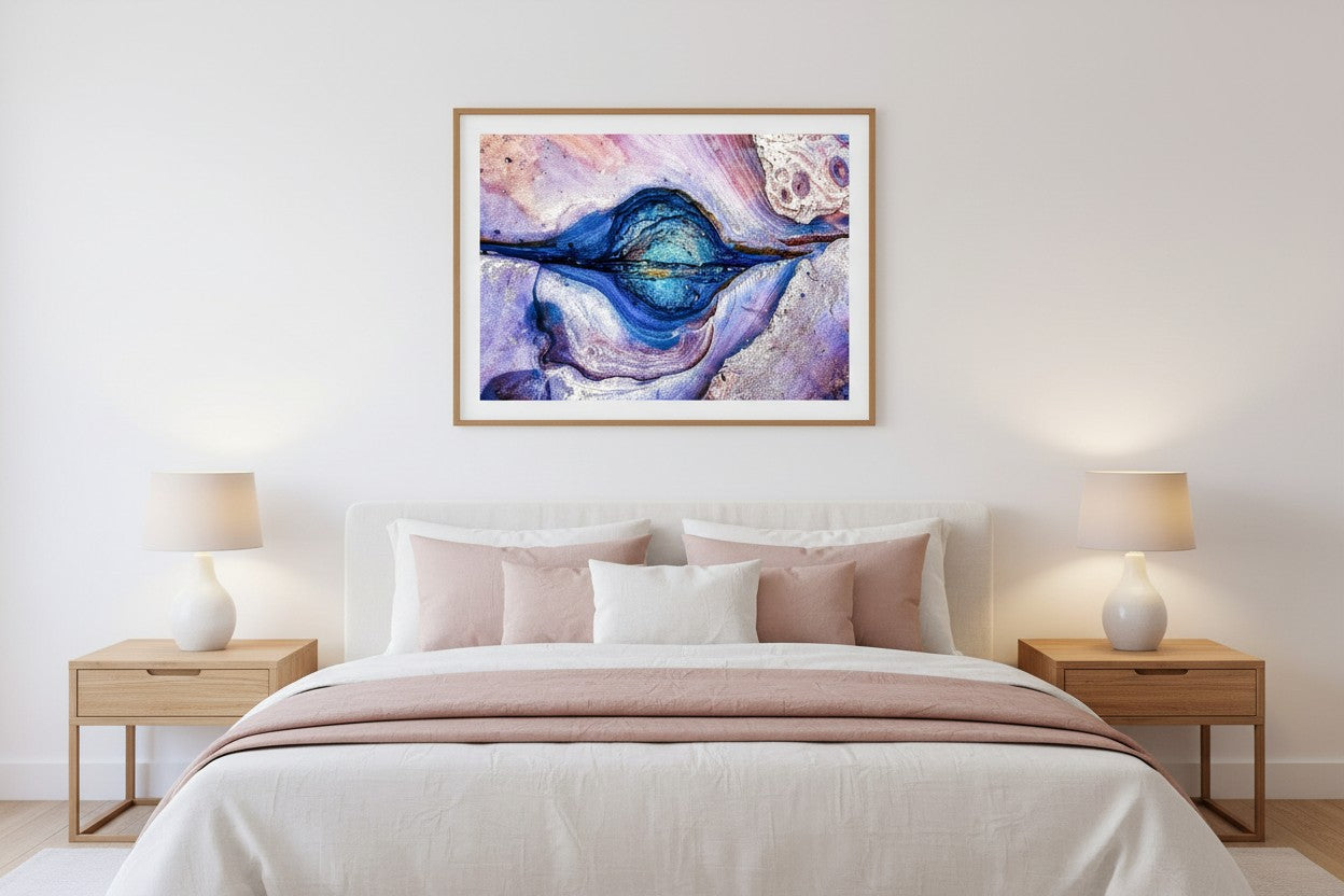 Rock Pool abstract coastal fine art print in a thin timber frame above a bed in a calm elegant bedroom with white and blush linen — unframed coastal wall art