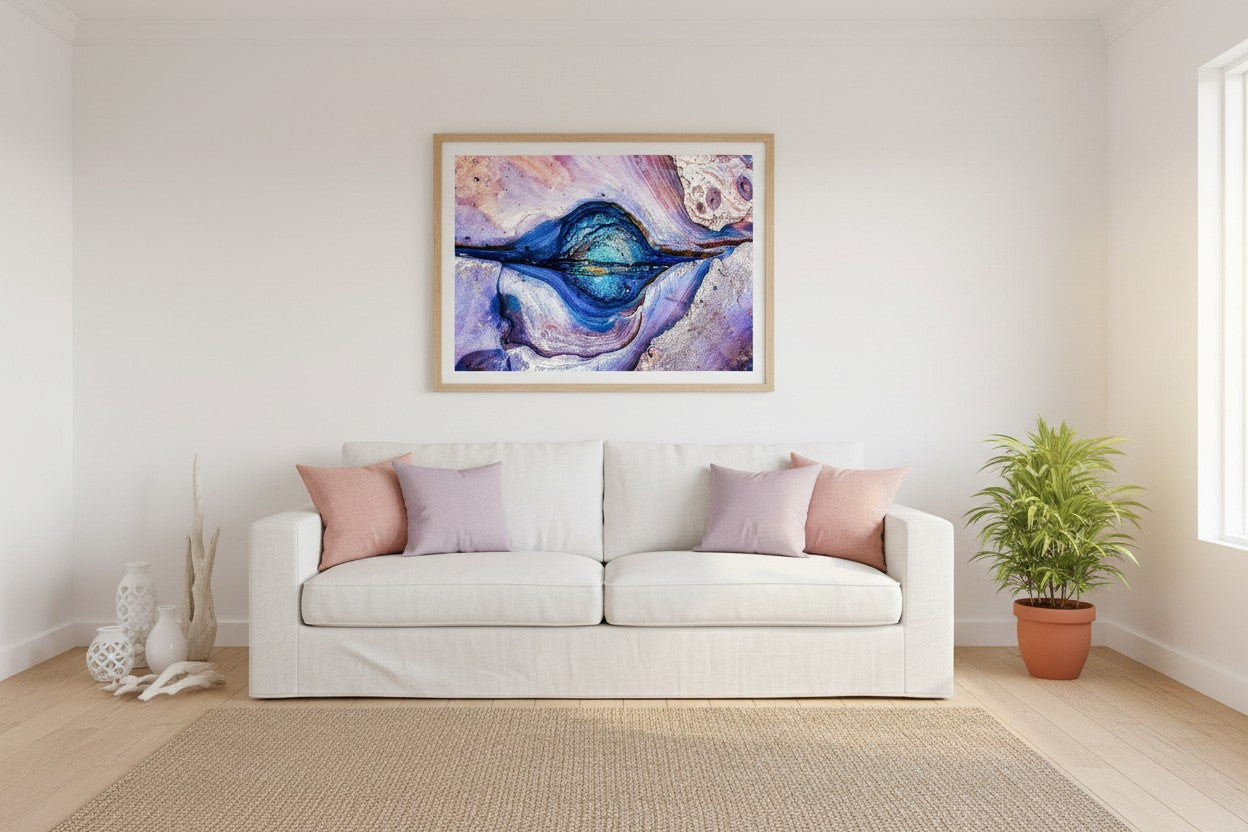 Rock Pool abstract coastal fine art print in a thin timber frame above a white linen sofa in a bright coastal Australian living room with blush and lavender accents — unframed wall art