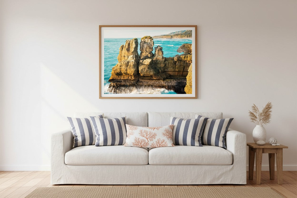 What Can You Sea fine art print in a thin timber frame above a white linen sofa in a bright coastal living room with navy and white accents — unframed wall art